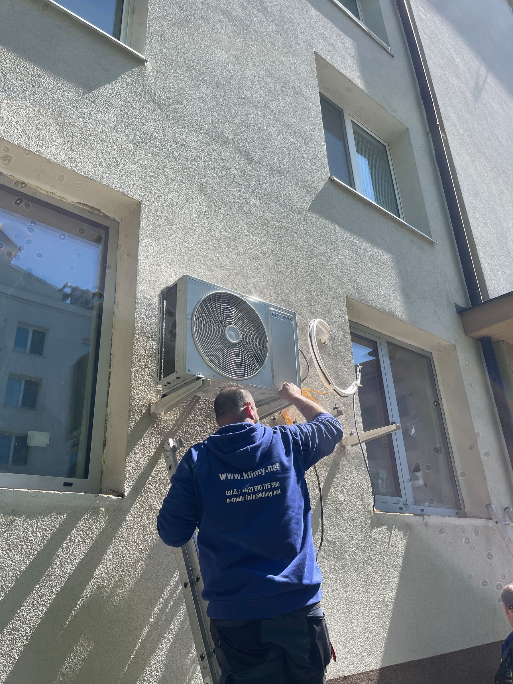 Technik Klimy.net montuje vonkajšiu jednotku klimatizácie na fasádu